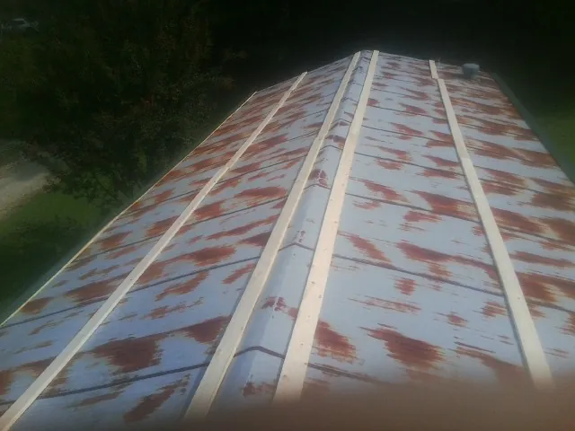 Rusted metal roof panels with new wood purlins before replacement — Storm Damage Roof Repair in Rockwell by Roofing Brothers