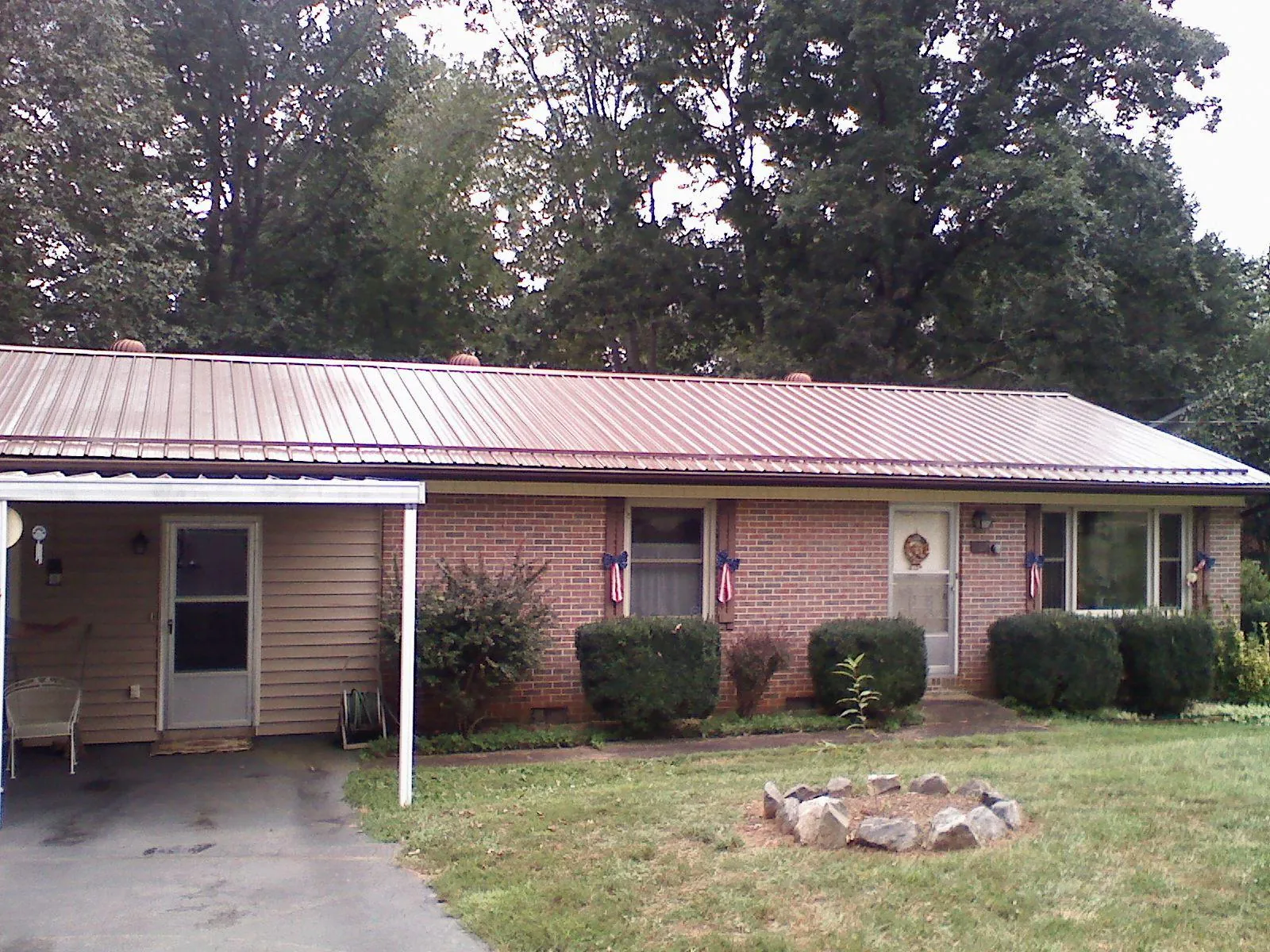 Bronze metal roof and carport on a brick ranch home — Roof Repair work by our crew in Rockwell